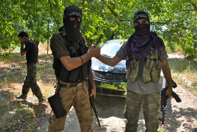 Ahmed et Bachir, deux soldats de l'ASL posant devant leur chef, Abou Alaa.  © Pierre Puchot